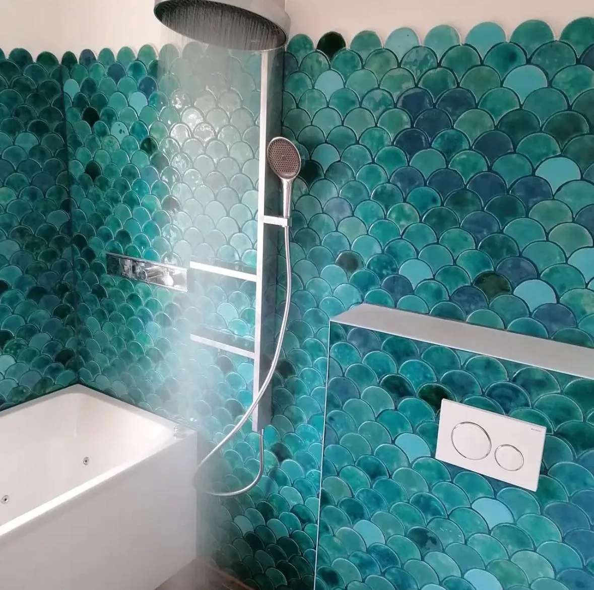 Badsanierung Wien mit handgemachten Fischschuppen-Mosaikfliesen in Türkis-Grün, Regenduschkopf, integrierte Wandnische, weiße Badewanne und Geberit Drückerplatte — Referenz 2F Installation OG