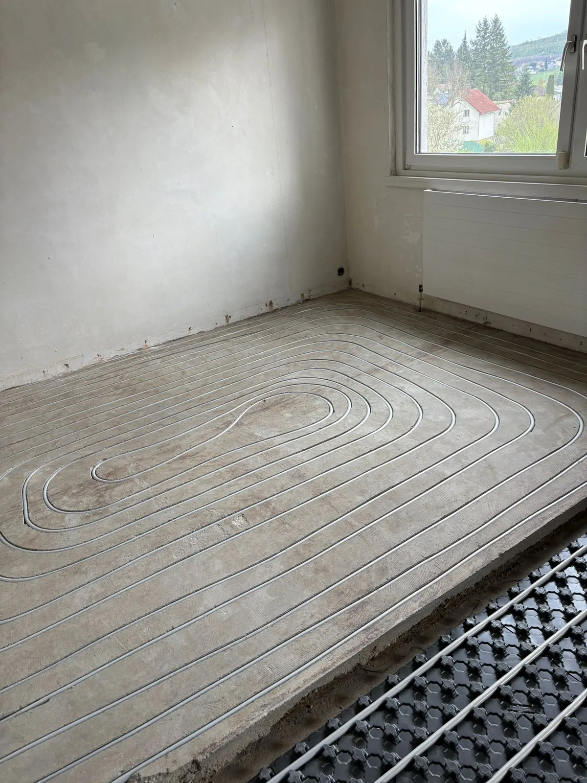 Fußbodenheizung fräsen Wien — verlegte Heizkreis-Rohre in millimetergenau gefrästen Kanälen im Zementestrich, daneben Noppenplatten-Verlegesystem als Vergleich (nachträgliche Verlegung im Wiener Altbau durch 2F Installation OG)